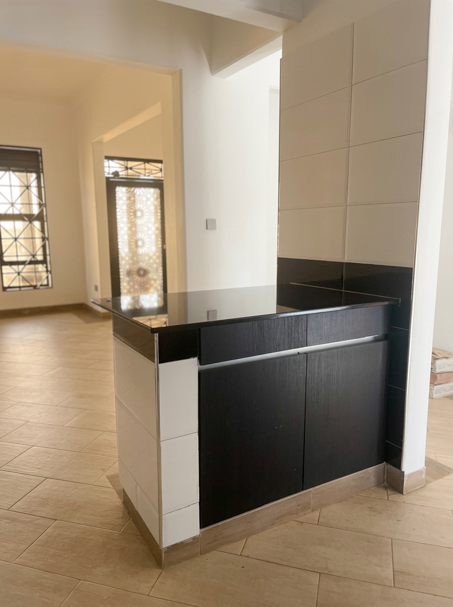 Bespoke breakfast counter in dark timber with polished granite top and tiled surround, opening onto a tiled living area